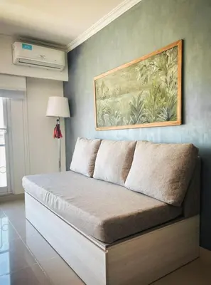 a bed in a room with a painting on the wall at Apart France - Un dormitorio con gim, piscina y estacionamiento in Río Cuarto
