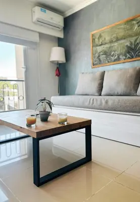 a coffee table in a living room with a couch at Apart France - Un dormitorio con gim, piscina y estacionamiento in Río Cuarto