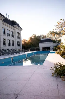 a swimming pool in front of a building at Apart France - Un dormitorio con gim, piscina y estacionamiento in Río Cuarto