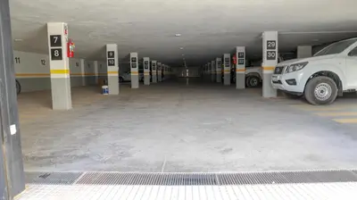 a parking garage with a car parked in it at Apart France - Un dormitorio con gim, piscina y estacionamiento in Río Cuarto