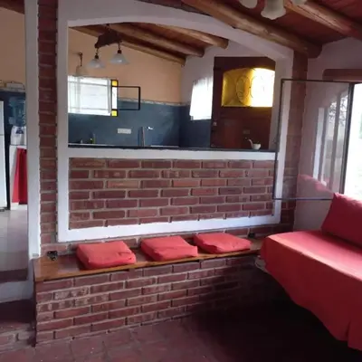 a row of red pillows sitting on a brick wall at cabañas fátima in Villa de Las Rosas