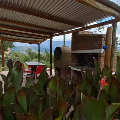 a patio with a roof and a table and some plants at cabañas fátima in Villa de Las Rosas