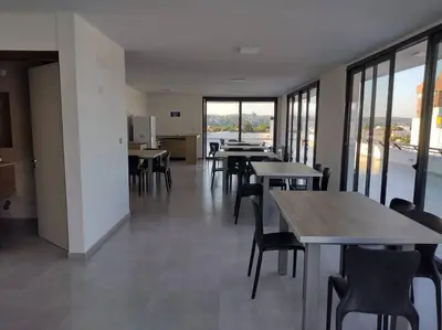 a dining room with tables and chairs and windows at Dto a estrenar Ctro V Carlos Paz in Villa Carlos Paz