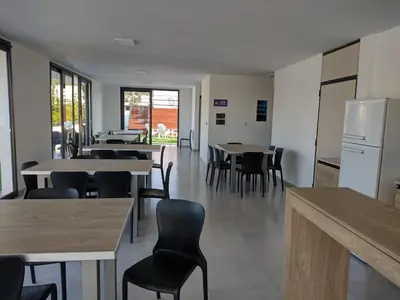 a dining room with tables and chairs and a refrigerator at Dto a estrenar Ctro V Carlos Paz in Villa Carlos Paz