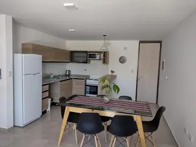 a kitchen with a table and chairs in a room at Dto a estrenar Ctro V Carlos Paz in Villa Carlos Paz