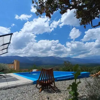 a wooden bench sitting next to a swimming pool at fatima cabaña 4personas in Villa de Las Rosas