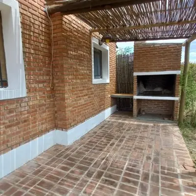 an outdoor patio with a brick wall and an outdoor fireplace at fatima cabaña 4personas in Villa de Las Rosas