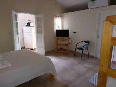 a bedroom with a bed and a television and a chair at La Soñada II in Alta Gracia