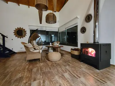 a living room with a fireplace and a stove at Hospedaje ideal a metros del rio in Los Reartes