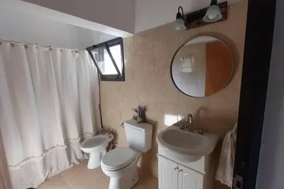 a bathroom with a toilet and a sink and a mirror at Hospedaje ideal a metros del rio in Los Reartes