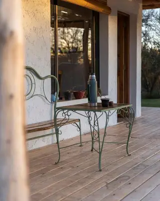 a bench sitting on a porch with a table at Hospedaje Sauce Linda - Casa Cina Cina in Villa Dolores