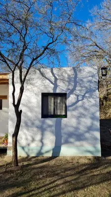a shadow of a tree on the side of a building at Hospedaje Sauce Linda - Casa Cina Cina in Villa Dolores