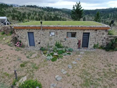 a stone house with a grass roof at Cabana Villa Alpina in Villa Alpina