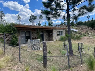 a stone house with a fence in front of it at Cabana Villa Alpina in Villa Alpina