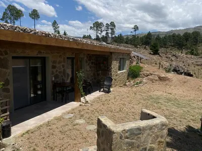 a stone house with a patio and a table at Cabana Villa Alpina in Villa Alpina