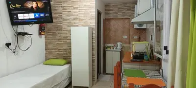 a small room with a couch and a tv on a wall at El Nogal monoambiente kichenete in Alta Gracia