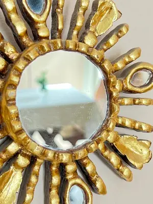 a gold mirror with a reflection of a room at Mi Universo in Villa Cura Brochero