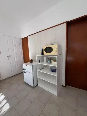 a small kitchen with a microwave on top of a refrigerator at Mi Universo in Villa Cura Brochero