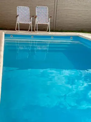 two chairs sitting next to a swimming pool at Mi Universo in Villa Cura Brochero