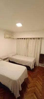 two beds in a room with wooden floors at Semipiso 3 Dormitorios 2 Baños Nueva Córdoba in Cordoba