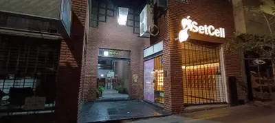 an entrance to a brick building with a neon sign at Semipiso 3 Dormitorios 2 Baños Nueva Córdoba in Cordoba