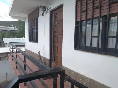 a house with a wooden door and a balcony at Encanto Urbano vcp in Villa Carlos Paz