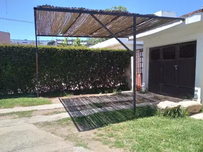 a pergola in front of a house at Encanto Urbano vcp in Villa Carlos Paz
