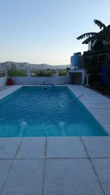 a swimming pool with blue water on a house at El Chañar in Villa Carlos Paz
