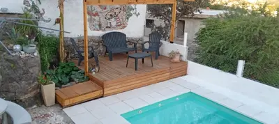 a deck with chairs and a table and a pool at El Chañar in Villa Carlos Paz
