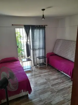 a bedroom with two beds and a window at El Chañar in Villa Carlos Paz