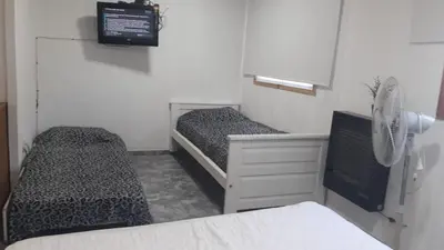 a small room with two beds and a fan at WENDY Ranch in Falda del Carmen