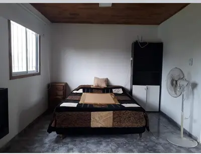 a bedroom with a bed in the corner of a room at WENDY Ranch in Falda del Carmen