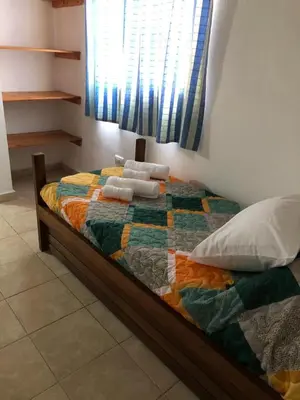 a bed with a colorful quilt and pillows on it at Los Manzanos in Villa Ciudad Parque
