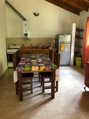 a kitchen with a table with chairs and a refrigerator at Los Manzanos in Villa Ciudad Parque