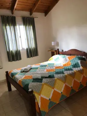 a bedroom with a bed with a colorful quilt on it at Los Manzanos in Villa Ciudad Parque