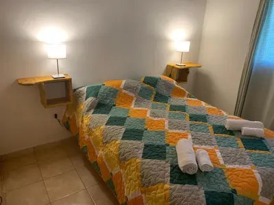 a bed in a room with two lamps on top of it at Los Manzanos in Villa Ciudad Parque