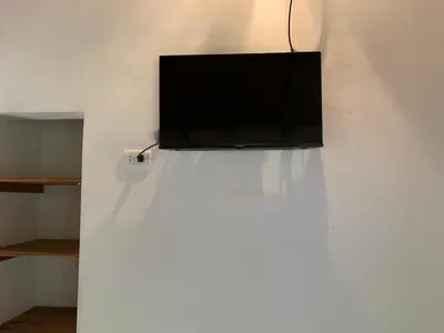 a flat screen tv on top of a white wall at Los Manzanos in Villa Ciudad Parque
