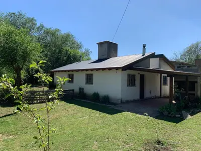 a small white house with a roof at Los Manzanos in Villa Ciudad Parque