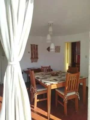 a dining room with a table and chairs and a window at Mediterránea Casa Vacanza in Villa Carlos Paz