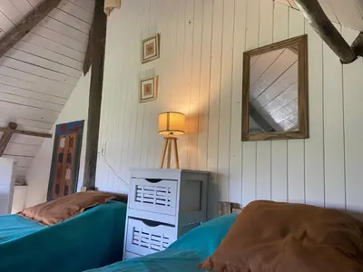 a bedroom with two beds and a dresser and a mirror at Descanso, aventura y ecoturismo en las sierras in San Francisco del Monte de Oro