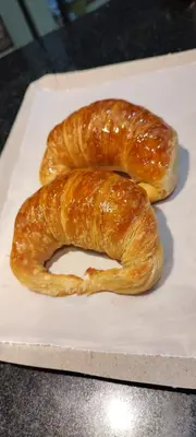 two croissants sitting on a white cutting board at Departamento Alta Cordoba 