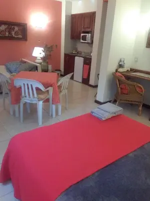 a living room with a table and a red rug at Paraiso Serrano in La Población