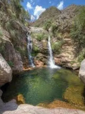 a pool of water next to a waterfall at Casa de montaña in Cortaderas