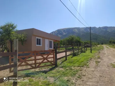 a house with a fence next to a dirt road at Casa de montaña in Cortaderas