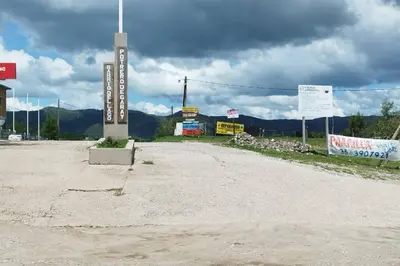 a dirt road with a sign in front of a building at Cabaña El Escape, Potrero de Garay, B del LAgo,600m del lago in Potrero de Garay