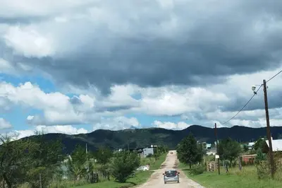a car driving down a road with mountains in the background at Cabaña El Escape, Potrero de Garay, B del LAgo,600m del lago in Potrero de Garay