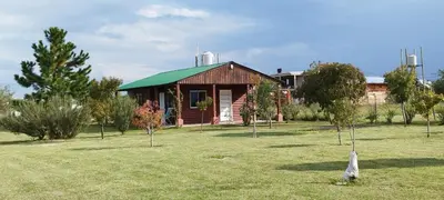 a small house with a green roof in a field at Cabaña El Escape, Potrero de Garay, B del LAgo,600m del lago in Potrero de Garay