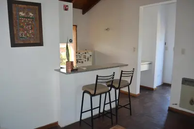 a kitchen with two bar stools and a counter at Loft terraza del norte a mts de sanatorio Allende, Hospital Privado y estadio Kempes in Cordoba
