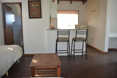 a room with two bar stools and a table at Loft terraza del norte a mts de sanatorio Allende, Hospital Privado y estadio Kempes in Cordoba