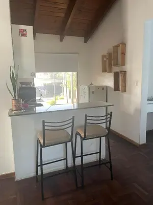 a kitchen with two stools and a counter in a room at Loft terraza del norte a mts de sanatorio Allende, Hospital Privado y estadio Kempes in Cordoba
